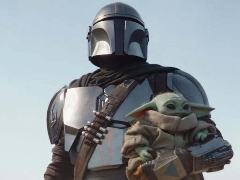 Grogu being held by Din Djarin in the Mandalorian season 3