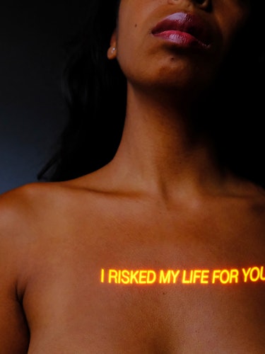 Portrait of an upper torso with a reflected light saying "I risked my life for you" on the chest