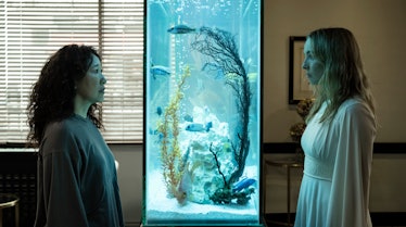 Eve and Villanelle staring at each other through a fish tank in the Killing Eve season 4 premiere