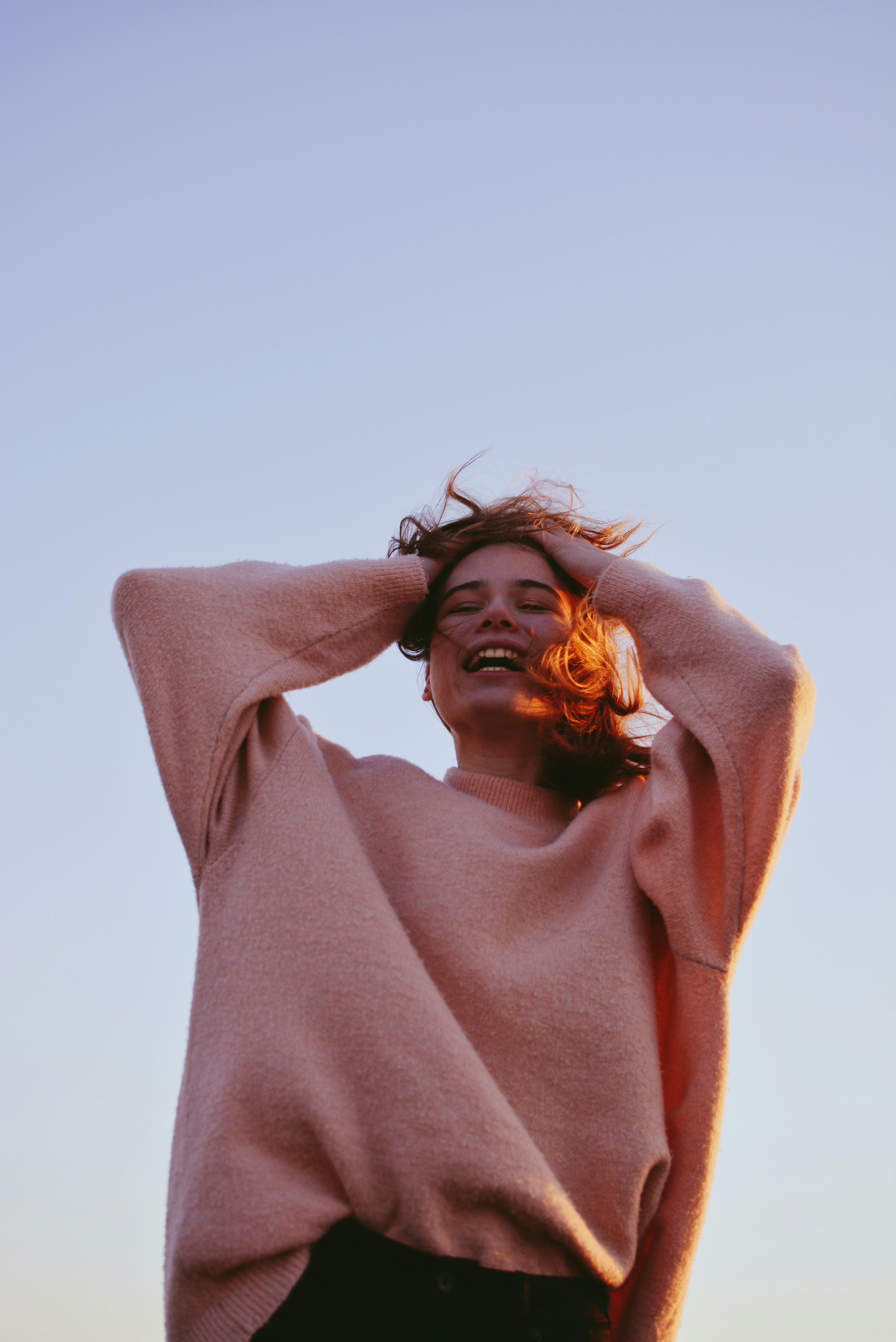 Young woman smiling at how the March 2022 new moon in Pisces is affecting her zodiac sign.