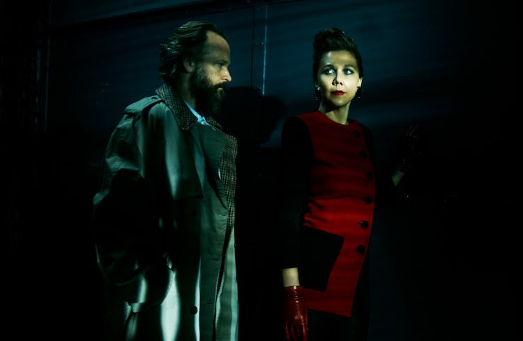 Peter Sarsgaard in a trenchcoat and Maggie Gyllenhaal in a red-black jacket
