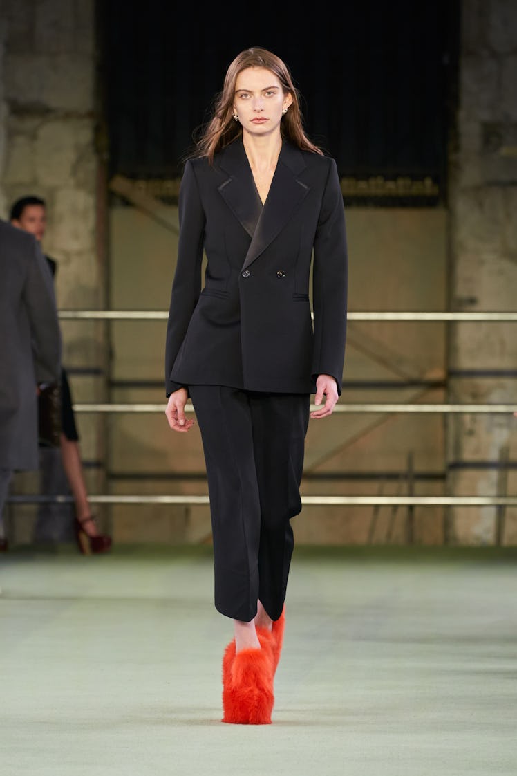 Model in black suit and red fuzzy shoes at Bottega Veneta fall 2022