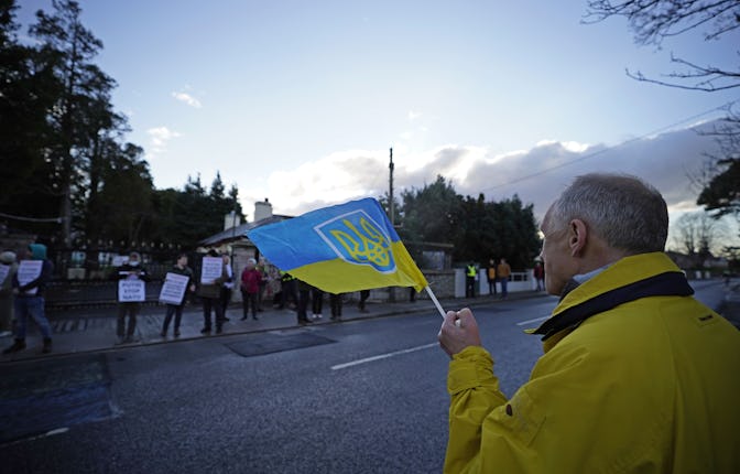 A protester in Dublin holding a flag with the Ukrainian coat of arms on Feb. 28, 2022.