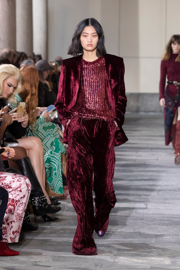 A model in a maroon suit walks down the runway at Etro Milan fashion week fall 2022