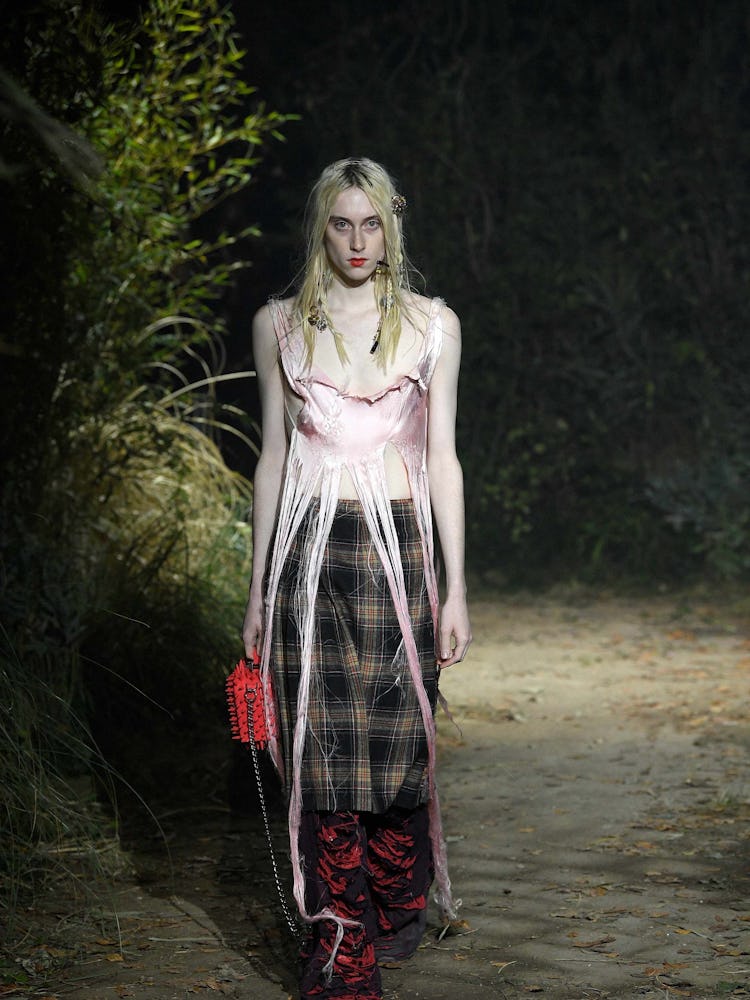 A model in a long plaid skirt and pink silk top at Marni fall 2022 Milan fashion week  