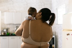 back of woman postpartum holding her baby