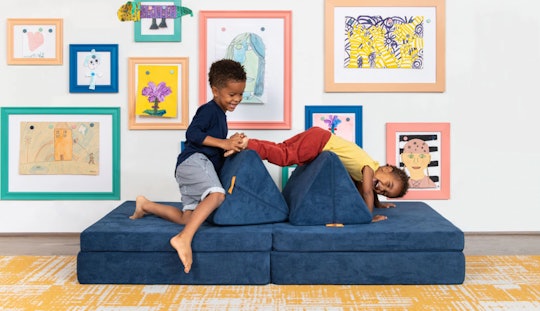 Two kids climbing and playing on a Nugget couch