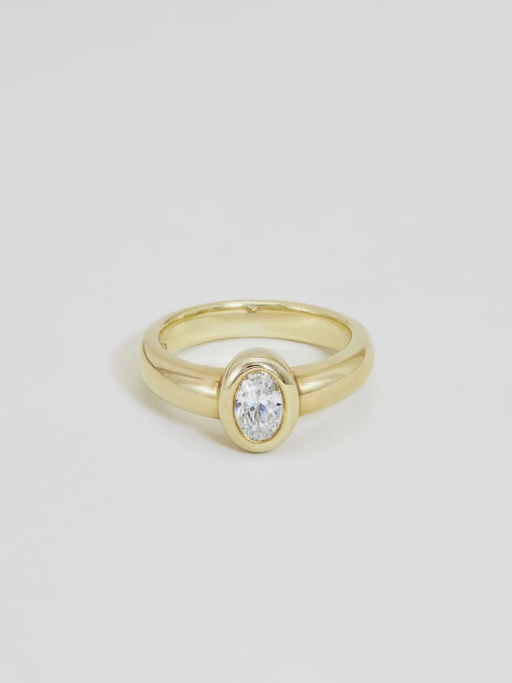 a bezel set oval ring in yellow gold