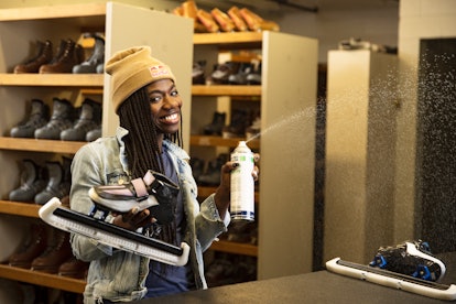 Speed skater Maame Biney holds up her skates in an equipment room.
