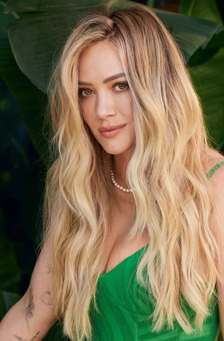 Hilary Duff wearing a green dress and pearl necklace.