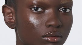 Model wearing Gucci's Eclat De Beauté Effet Lumière, a face gloss.