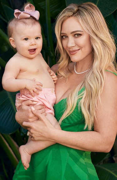 Hilary Duff wearing a green Brandon Maxwell dress while holding her daughter 