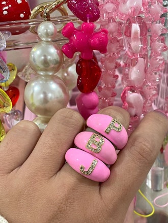a hand with bright pink enamel rings on its finger