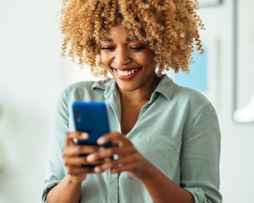 smiling woman looking at her phone