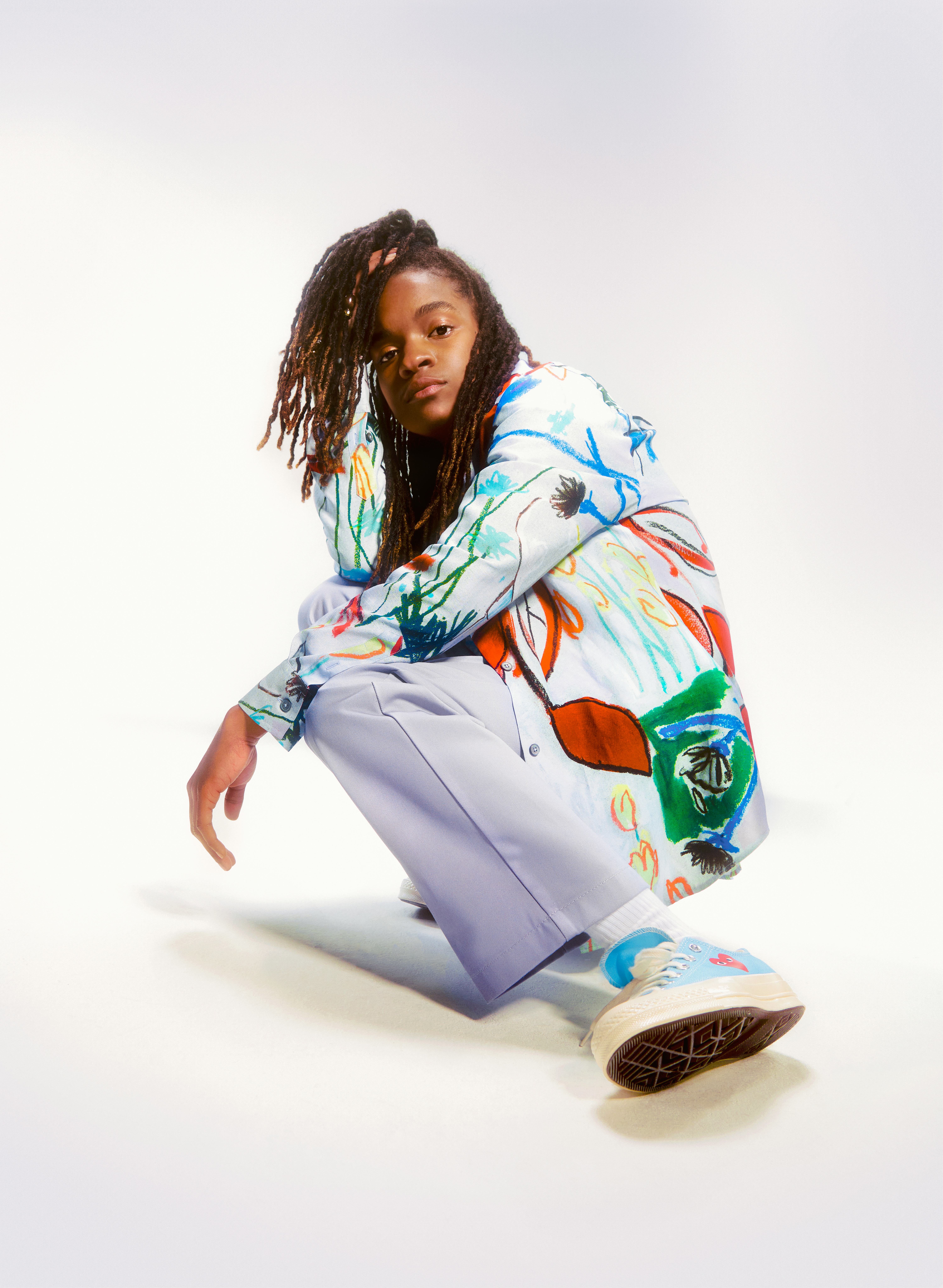 Reggae singer, songwriter, rapper, DJ and a guitarist Koffee posing in a colorful combination.