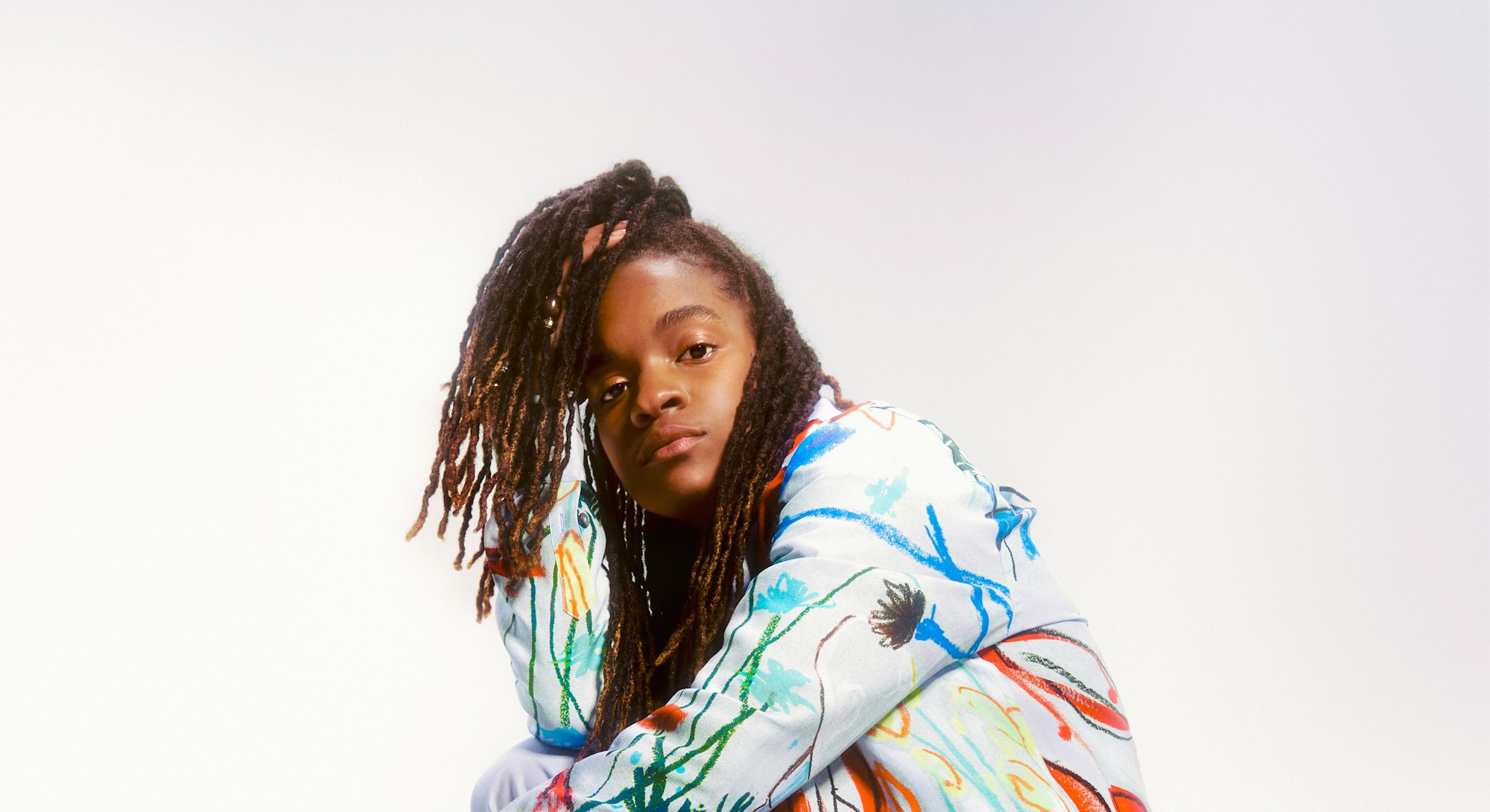 Reggae singer, songwriter, rapper, DJ and a guitarist Koffee posing in a colorful combination.