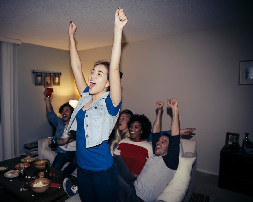 adults cheering and having fun watching sports and having game night