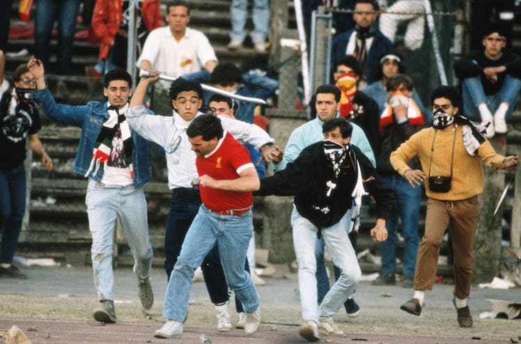A Liverpool fan is chased by opposing Juventus fans during a pitched battle prior to the 1985 Europe...