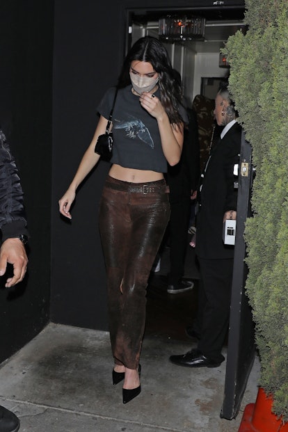 Kendall Jenner wears low-rise brown leather pants.