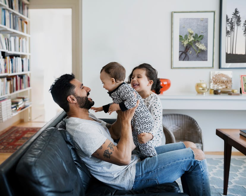 Dad playing with two kids on the couch