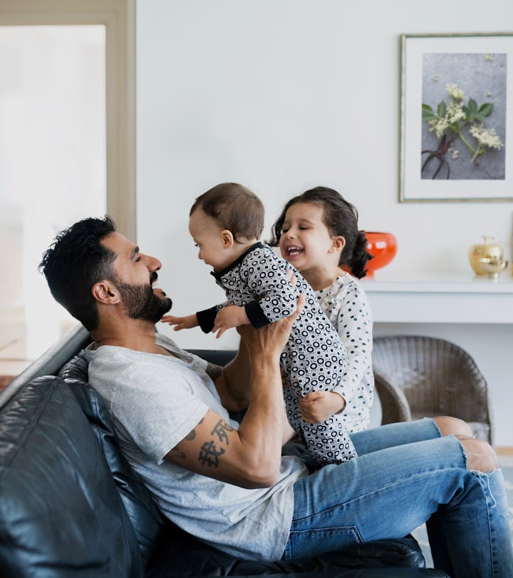 Dad playing with two kids on the couch