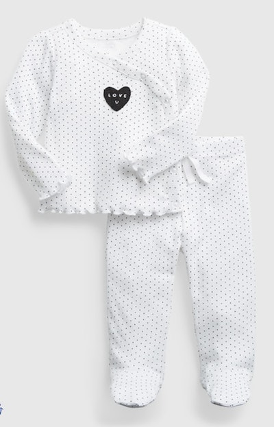 Flat lay of baby girl outfit; top and pants with black dots