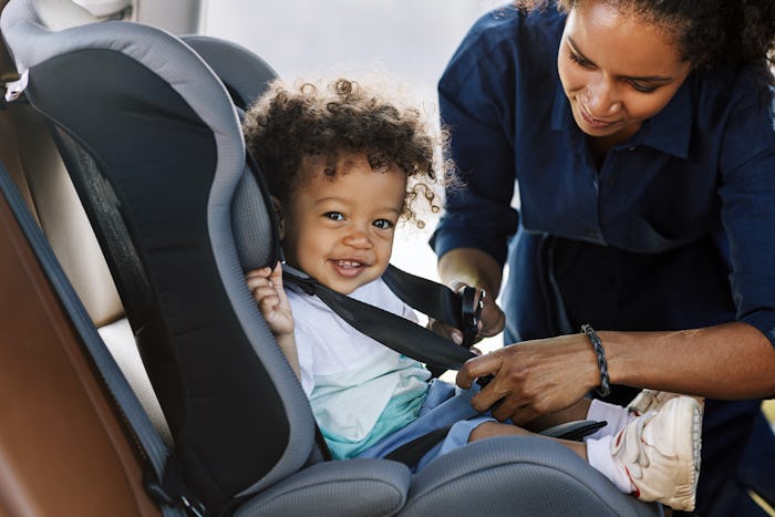 A mother adjust one of the 6 best convertible car seats with her baby in it