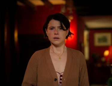 Jessie Buckley in a brown cardigan looking scared