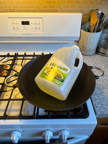 A picture of a wok holding vegetable oil.