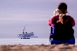 Seal Beach, CA - December 16: A person looks out over the ocean with a view of oil platform Esther a...