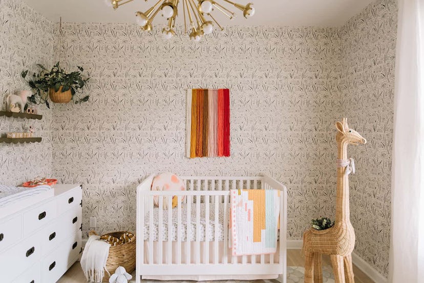 gender neutral baby nursery with rattan giraffe and focal lighting fixture