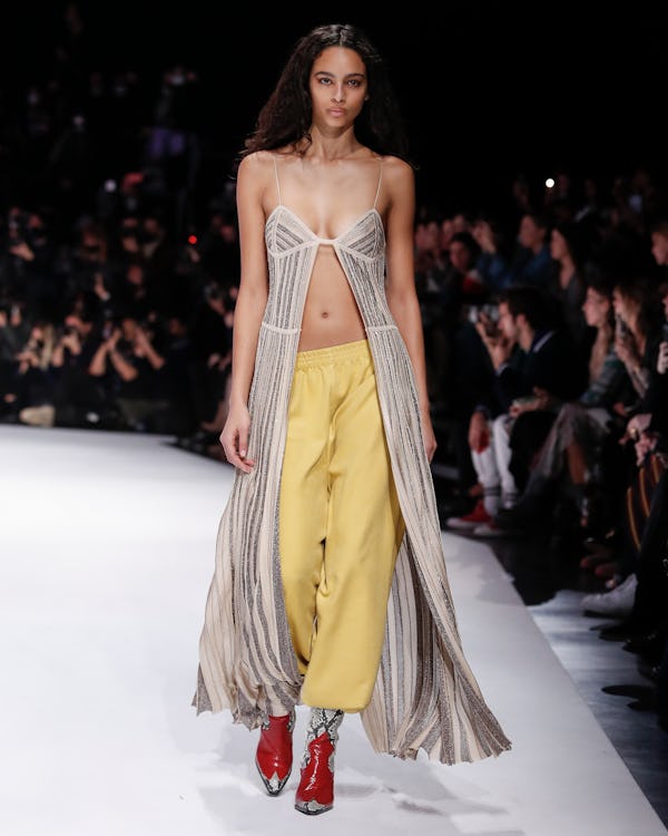 A model wearing a metallic bra maxi top and yellow joggers on the Missoni runway