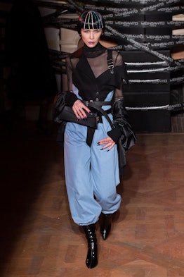 A model in a black sheer top and blue trousers walks the runway at Weinsanto Paris fashion week fall...