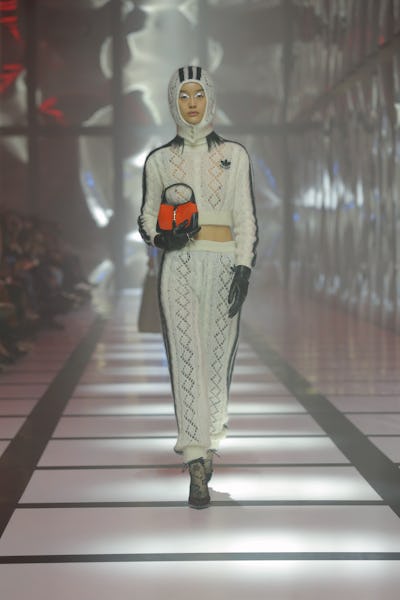 A model wearing a black and white crochet cropped jacket a maxi skirt on the Gucci runway