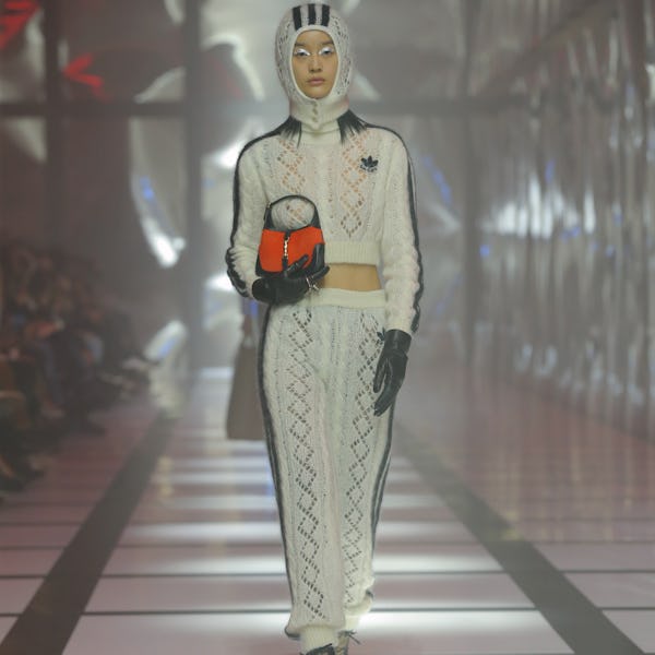 A model wearing a black and white crochet cropped jacket a maxi skirt on the Gucci runway