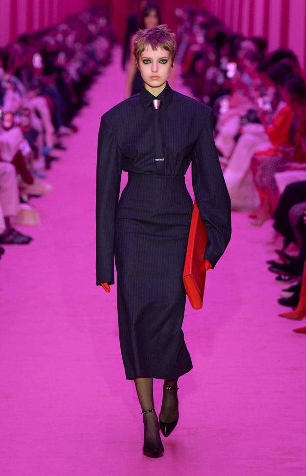 A model wearing a tailored pinstripe shirt and pencil skirt on the Sportmax Runway