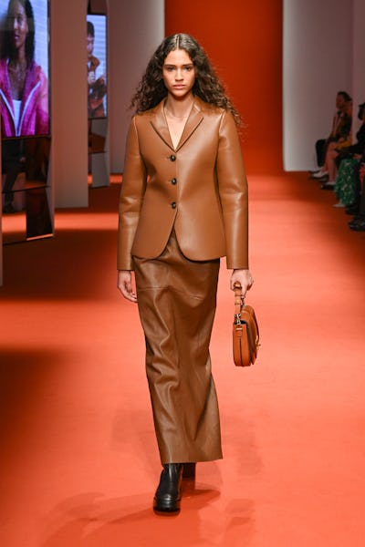 a model wearing a sweater a brown leather blazer and maxi skirt on the Tod's runway