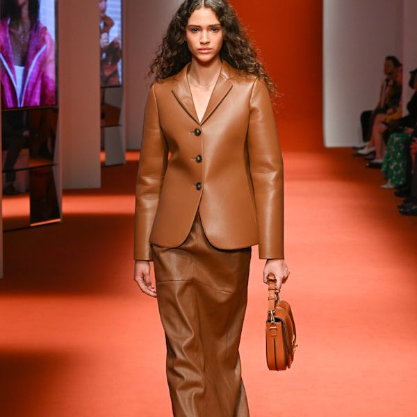 a model wearing a sweater a brown leather blazer and maxi skirt on the Tod's runway