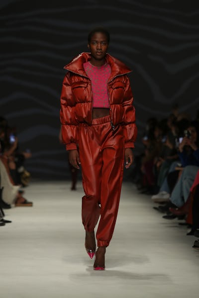 A model wearing a red puffer coat leather joggers on the Genny runway