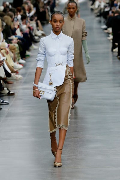 A model wearing a bustier-style button-down shirt and leather skirt on the Fendi runway