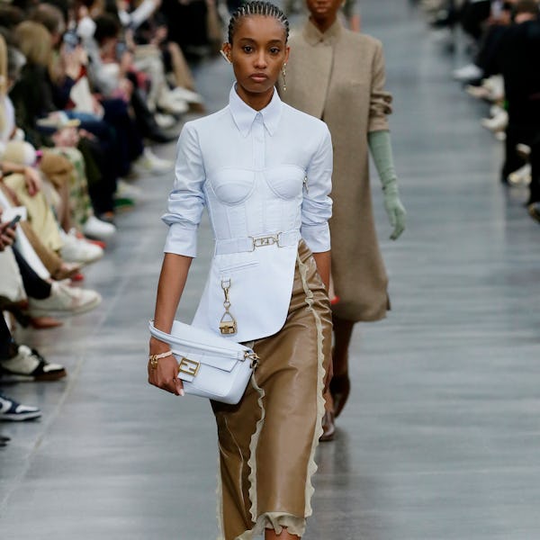 A model wearing a bustier-style button-down shirt and leather skirt on the Fendi runway
