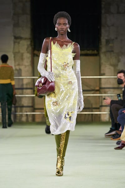 a model wearing a yellow sequin dress on the Bottega Veneta runway