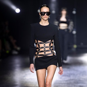 a model wearing a cutout leather minidress on the Roberto Cavalli runway