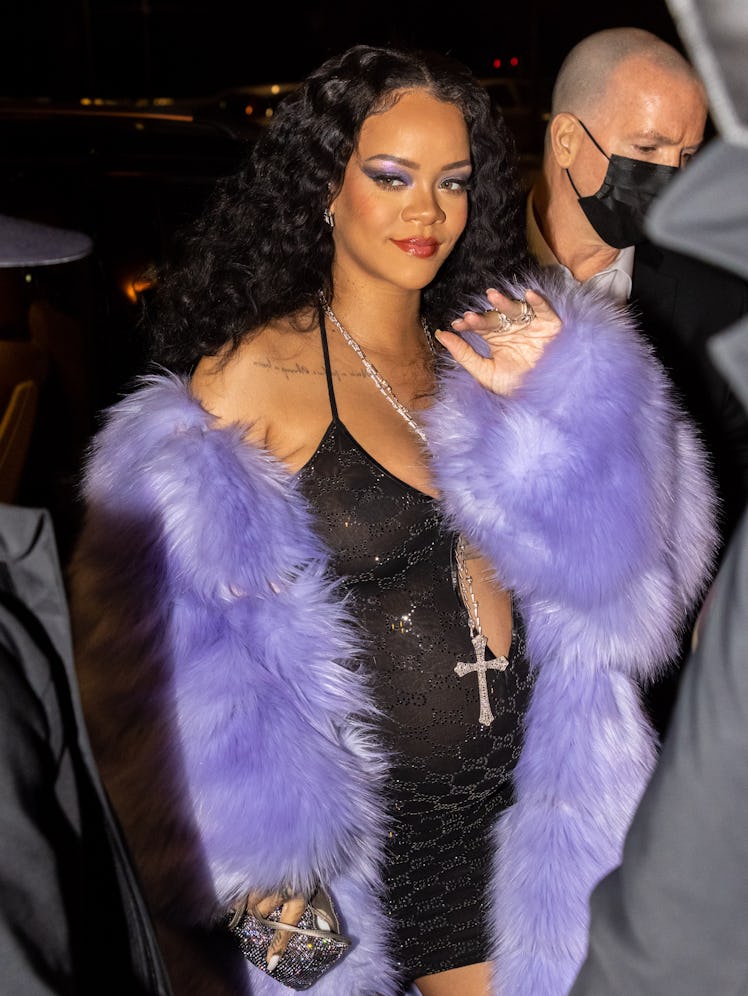 A pregnant Rihanna wearing purple fur and a sheer dress