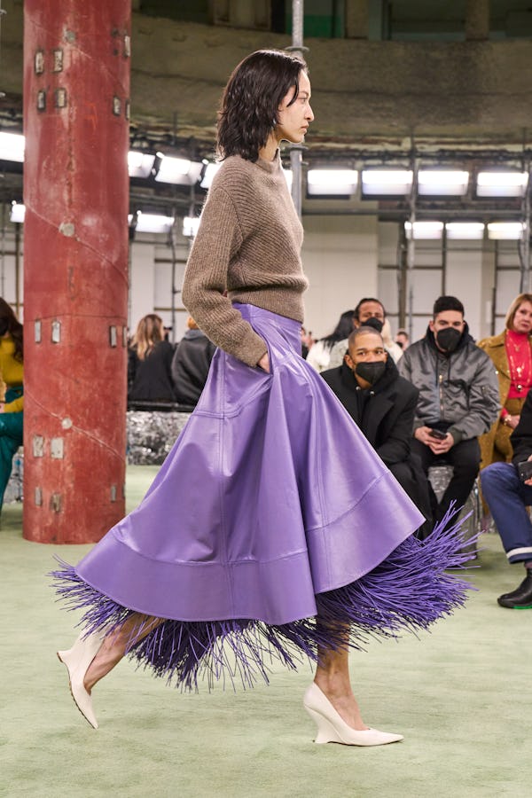 a model wearing a sweater a purple leather skirt on the Bottega Veneta runway