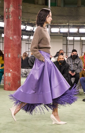 a model wearing a sweater a purple leather skirt on the Bottega Veneta runway