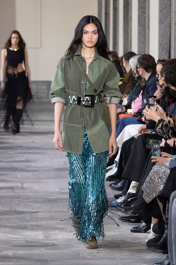 a model wearing a turquoise sequin maxi skirt and green utility jacket on the Etro runway
