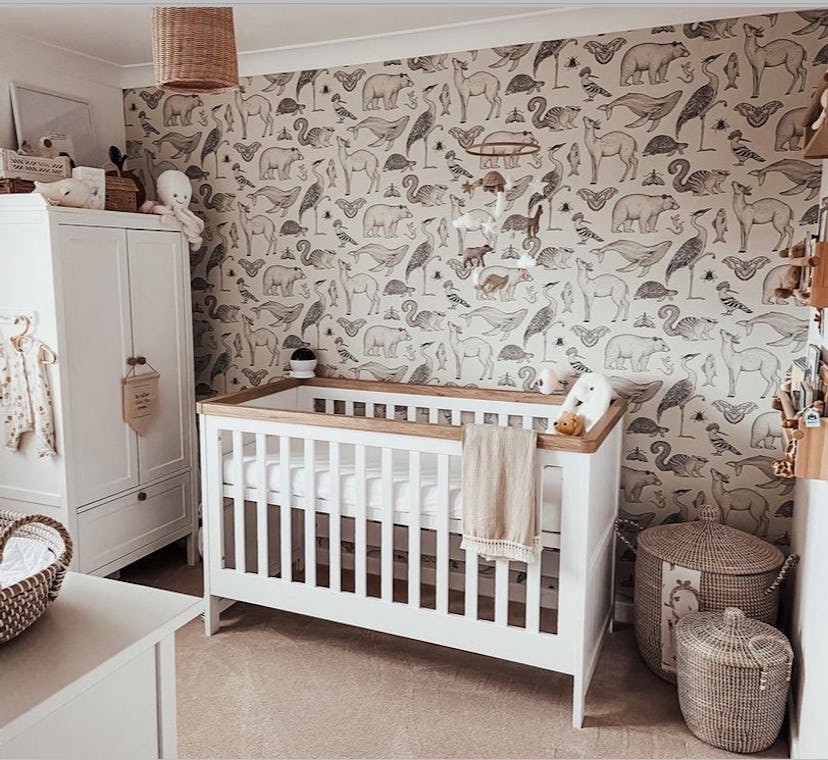 gender neutral baby nursery with animal wallpaper