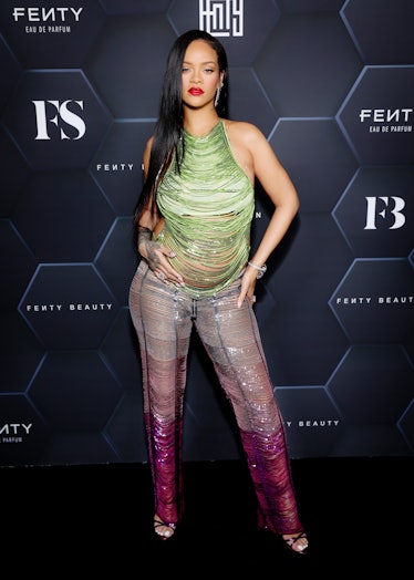 A pregnant Rihanna wearing a glittery green and pink ensemble