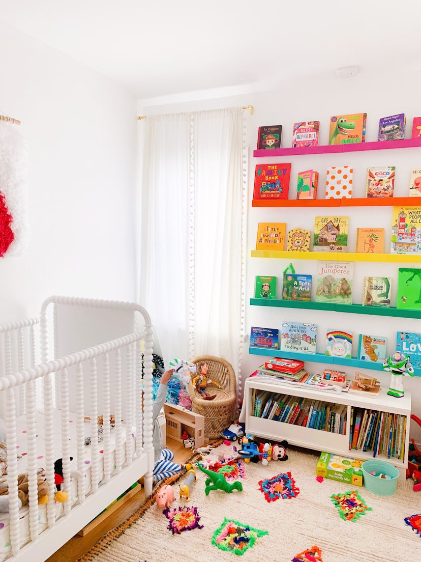 colorful gender neutral nursery with rainbow shelves